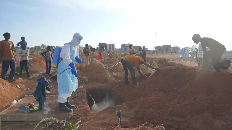 A health worker sprays disinfectant in a freshly dug grave in Bunia, 12 August, 2026 (Copyright: AP Photo)