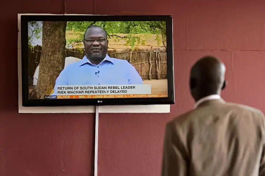 A man watches the news headlines about rebel leader Riek Machar's return to Juba, the capital of South Sudan, in April 2016 (Image: CARL DE SOUZA/AFP via Getty)