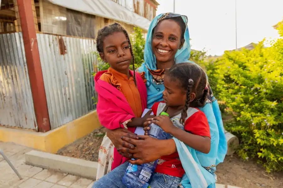 At an IOM health clinic near the Sudan border, Marida sits with two of her daughters, receiving care that offers a measure of stability amid ongoing uncertainty (Photo: IOM 2025/Amber Christino)