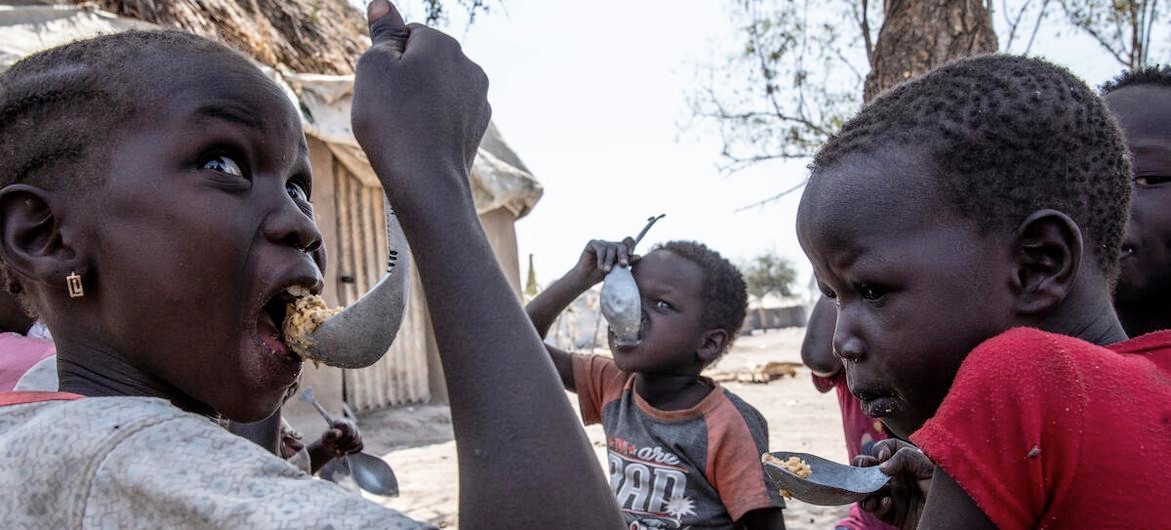 WFP Children in Fangak county, Jonglei State eat a cooked meal of sorghum. WFP provides food rations to food insecure families containing sorghum, oil, salt, peas and maize (January 2022).