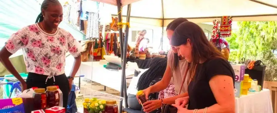 file:///mnt/212ca0e0-0bde-497f-af03-681e679e4f2a/Downloads/_Pachodo Images/Founder of Pure Organic South Sudan Honey, June Owdo Joseph Ojukwu (left), engages with customers as they try her honey (Photo Credit_ African Development Bank Group)