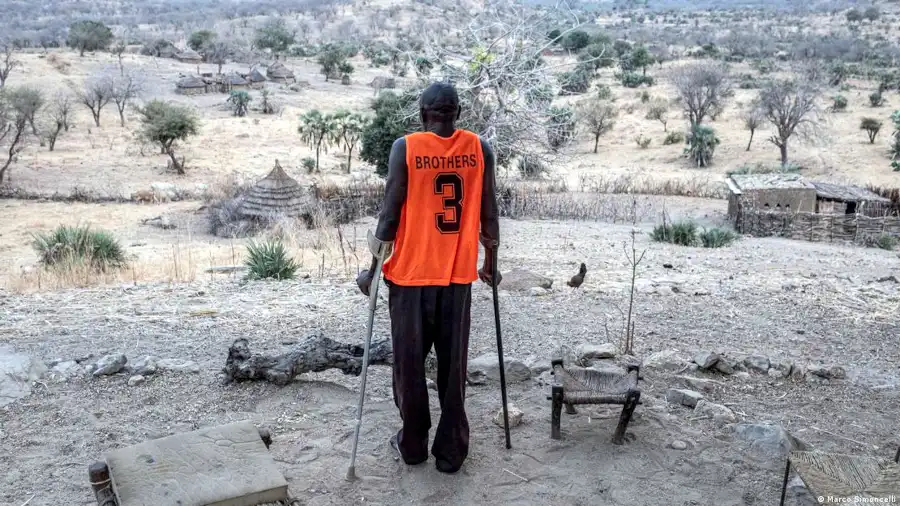 Hassan Koko stands on crutches overlooking the landscape from his village near Gidel in South Kordofan (Image: Marco Simoncelli)