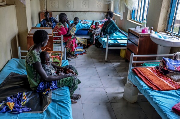 Mothers sit with their children in the malnutrition ward of Bor State Hospital in Bor, South Sudan, Monday, Aug. 18, 2025. (AP Photo/Caitlin Kelly)