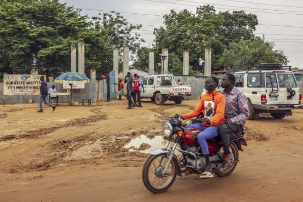 Motorists pass outside Bor State Hospital in Bor, South Sudan, Monday, Aug. 18, 2025. (AP Photo/Caitlin Kelly)