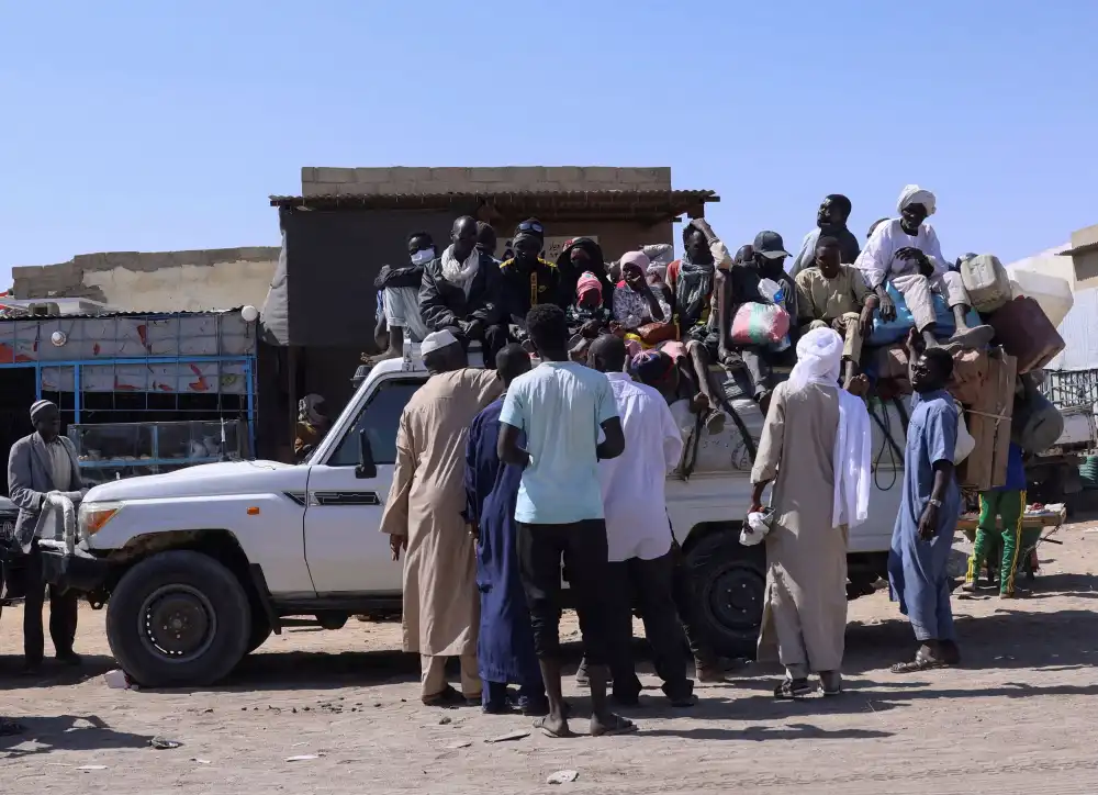 People sit on a pickup truck as they prepare to travel about 250 km south to Adre, on the Chad-Sudan border, at a transport station in Tine, eastern Chad, November 25, 2025 (REUTERS/Amr Abdallah Dalsh/File Photo)