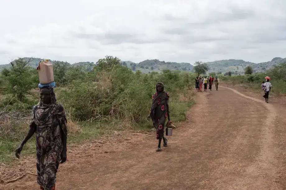 People walk along the road out of the Tiamushro camp for internally displaced persons (IDP) in Kadugli, South Kordofan state, on June 18, 2024. [GUY PETERSON / AFP / Getty Images]