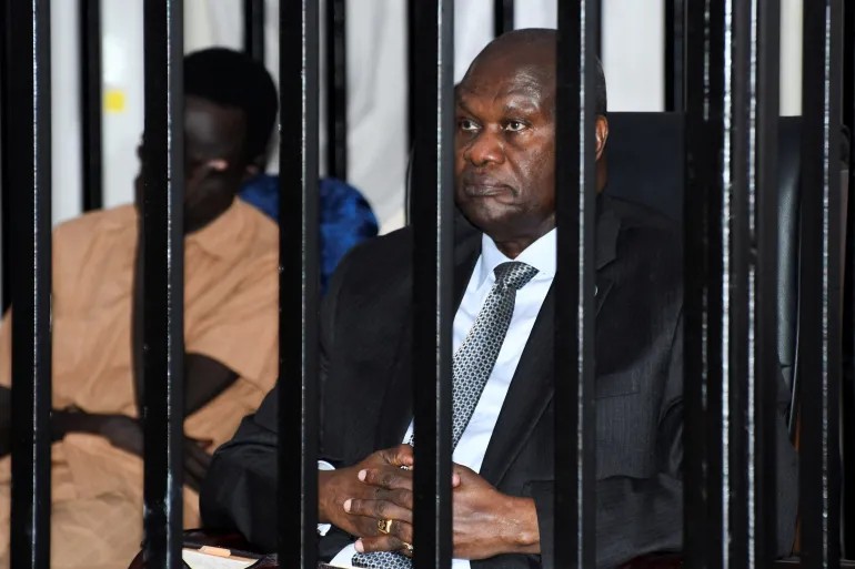 South Sudan’s suspended First Vice President Riek Machar sits inside a steel cage dock during his trial on charges including treason and crimes against humanity, at the Freedom hall in Juba, South Sudan, September 29, 2025 [File: Jok Solomun/Reuters]