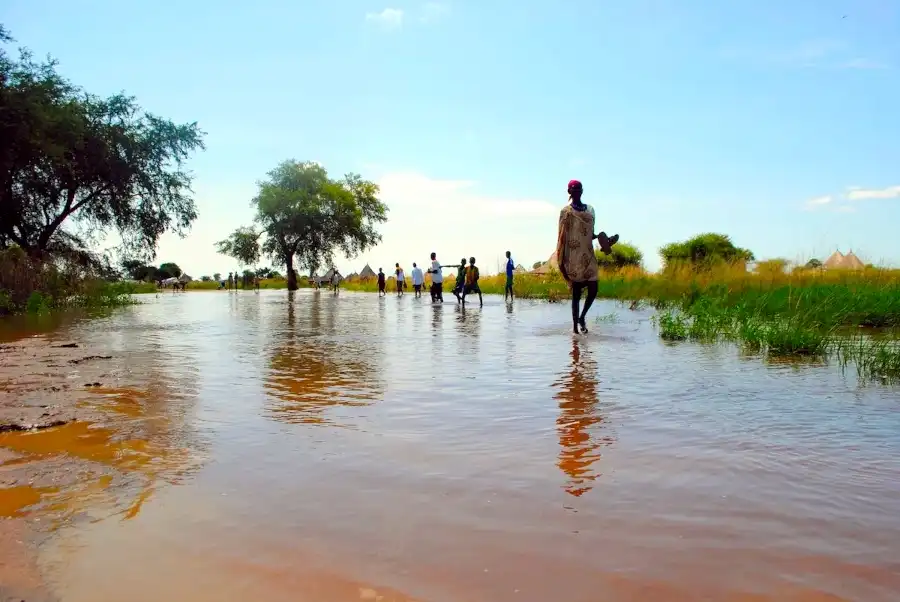 South Sudanese refugees wade through a flooded camp on October 16, 2014 in the western state of Gambella in Ethiopia (Photo Credit: AFP)