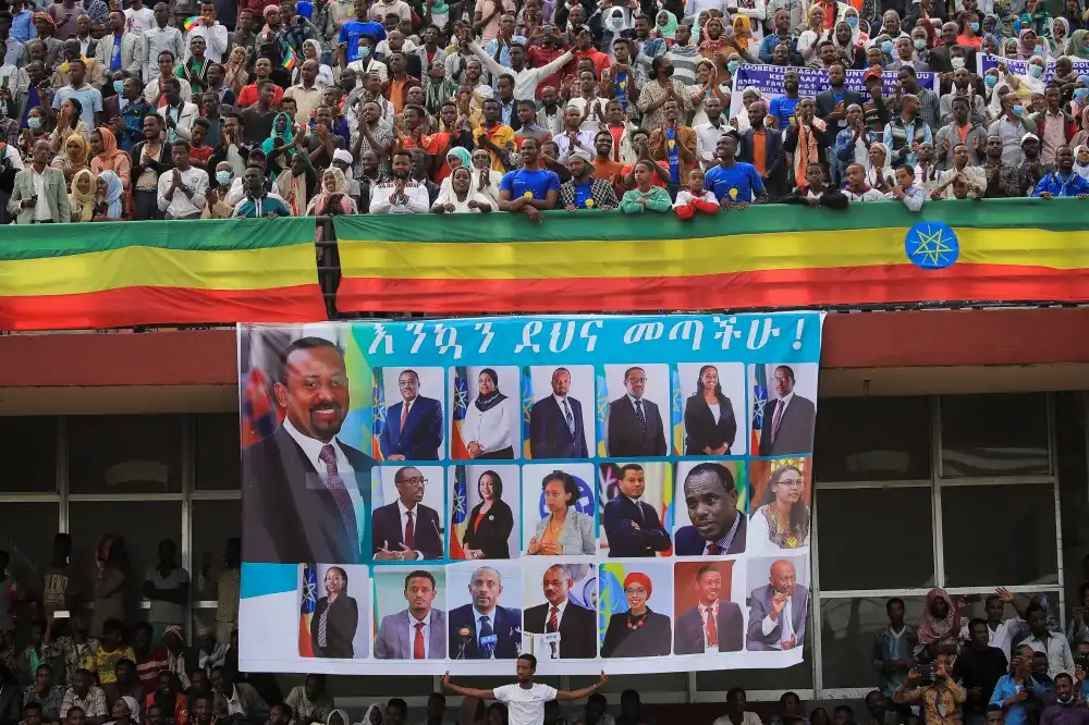 Supporters of Ethiopian Prime Minister Abiy Ahmed stand near a banner, as they attend his last campaign event ahead of Ethiopia’s parliamentary and regional elections scheduled for June 21, in Jimma, Ethiopia, June 16, 2021 (REUTERS/Tiksa Negeri)
