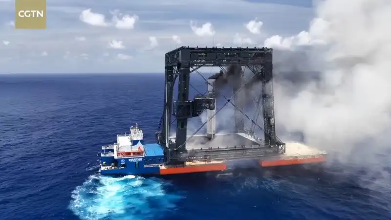 The first-stage booster of the Long March-10B rocket descends vertically toward the recovery net aboard the “Navigator” vessel on July 10, 2026. [Photo: CGTN]